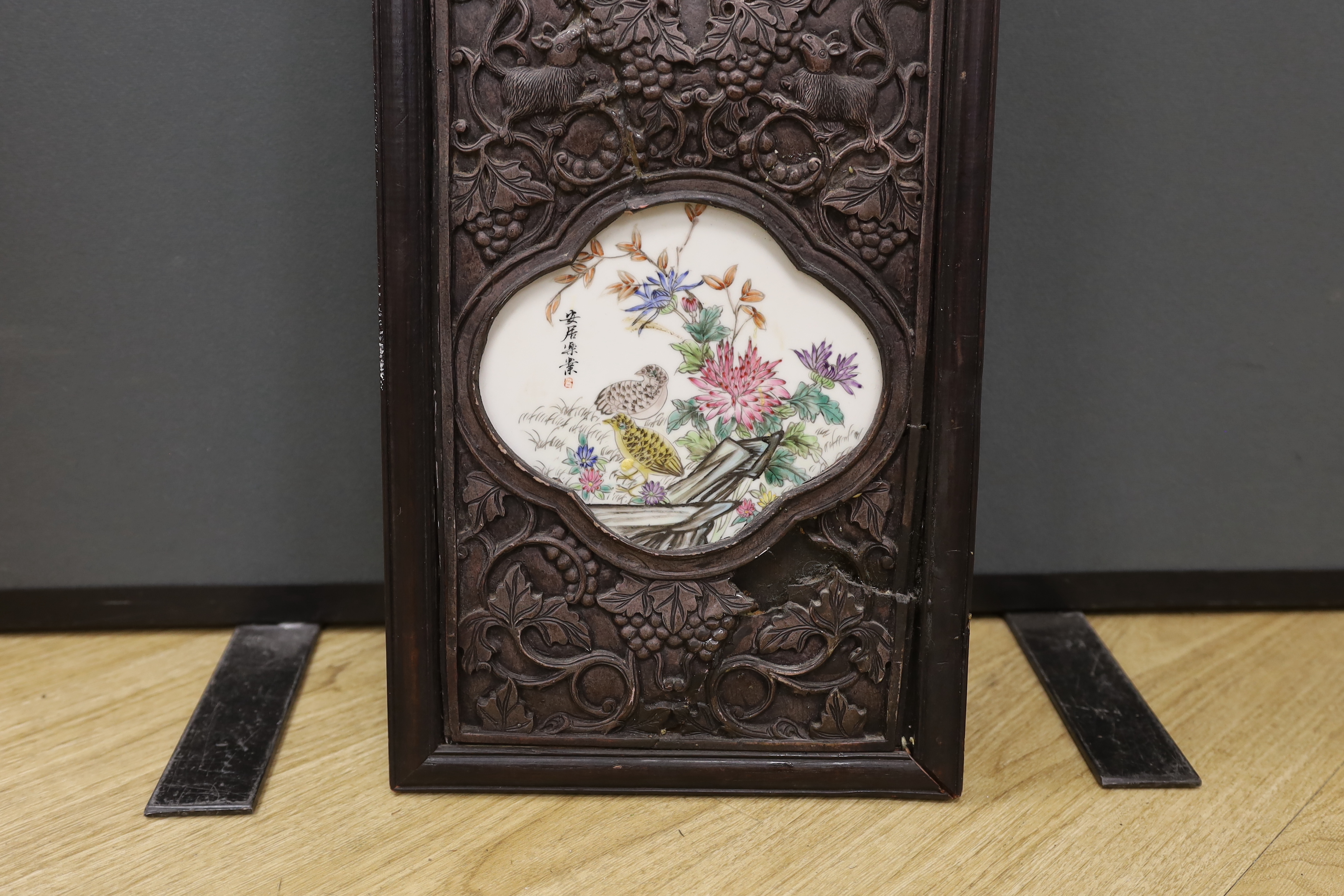 A Chinese famille rose porcelain panel, housed in a carved hardwood frame, 106cm high